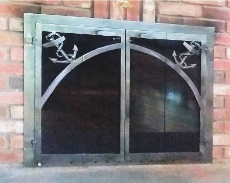 Mariners horizon fireplace doors all natural iron finish with anchor motif. vice bifold doors and smoked glass. Comes with slide mesh